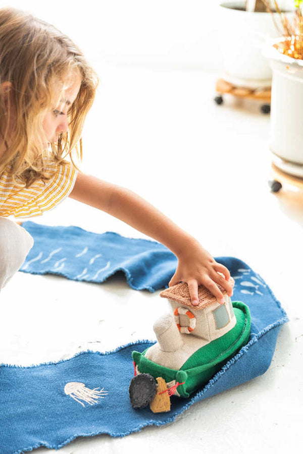 kindje speelt met speelgoedboot en zijn fantasie