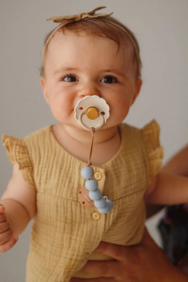 Baby met bloemetjes fopspeen en tutketting