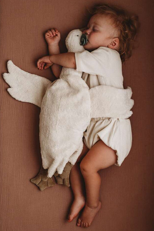 slapende baby met witte knuffelgans warmtekussen warmteknuffel