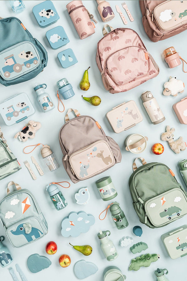 Flat lay met de mooiste producten uit de Done by Deer back to school collectie: kleuterrugzakjes, brooddozen, drinkflessen...