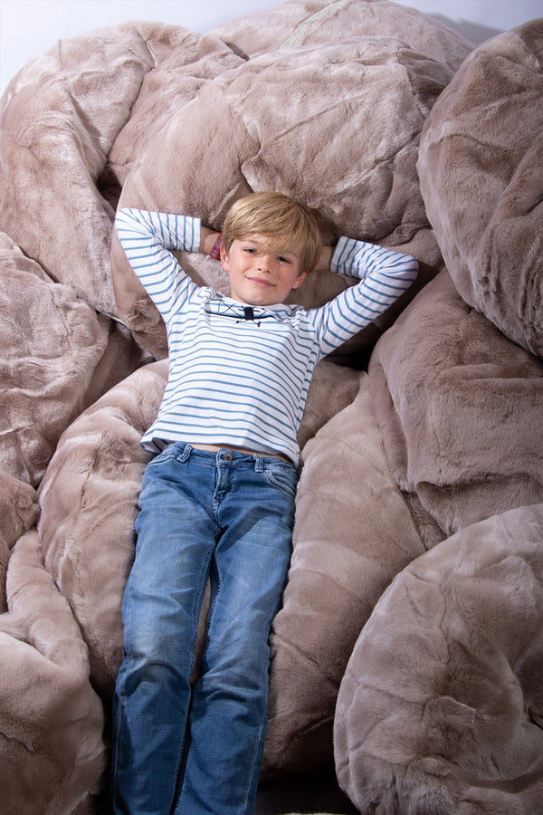 Jongen ligt te chillen op een hele reeks Wild & Soft Bean Bags - In den Olifant